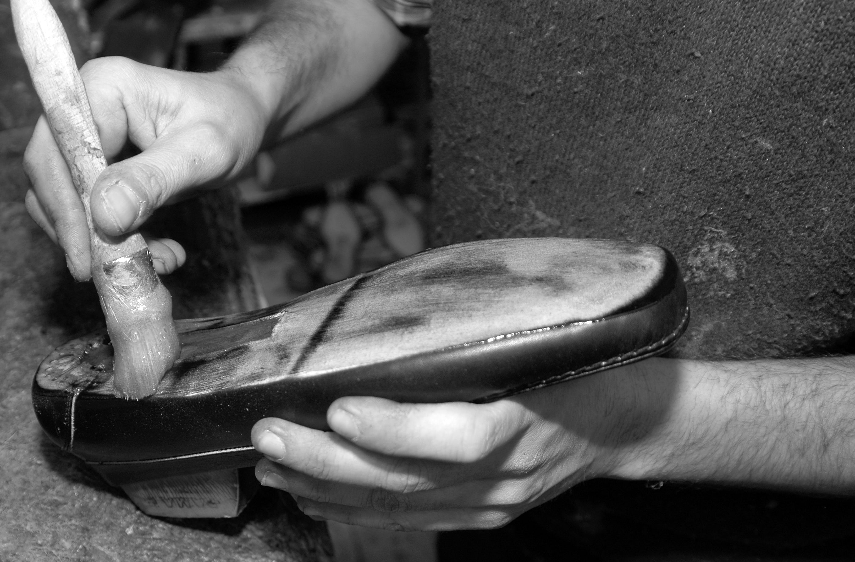 Artigiano che applica l'intersuola su una scarpa Calpierre